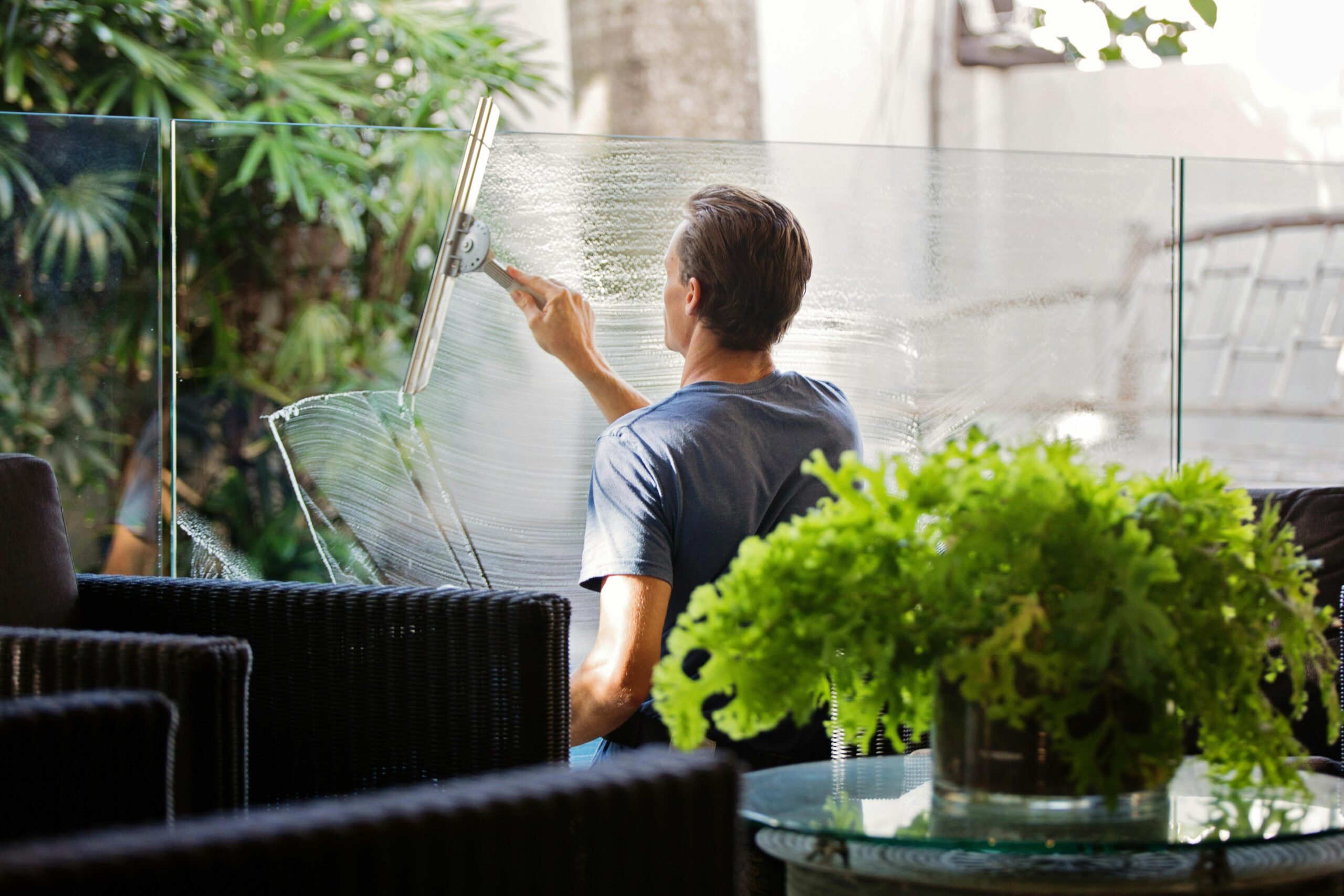 Window cleaner cleaning a balcony pane glass
